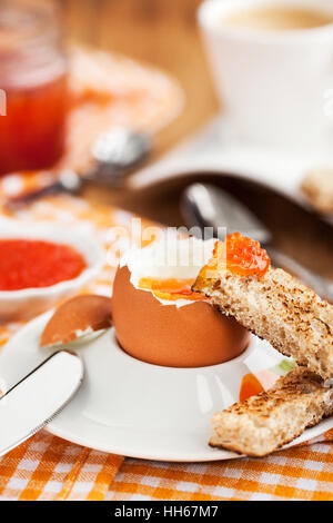 Uova sode con caviale rosso, pane tostato e caffè per colazione Foto Stock