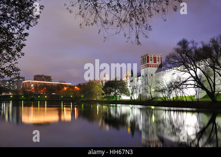 Le mura e le torri di il Convento Novodevichy incorniciata dagli alberi al crepuscolo. Mosca Cityscapes una notte Foto Stock