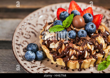 Banoffee pie (tart) decorato con cioccolato fresco, mirtillo e fragola Foto Stock