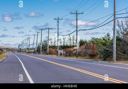 Un lungo rettilineo e Montauk autostrada con un accompagnamento La linea elettrica e poli Foto Stock