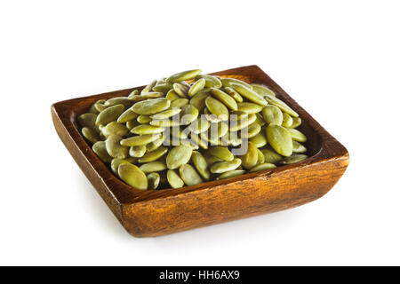 I semi di zucca in ciotola di legno isolato su sfondo bianco Foto Stock