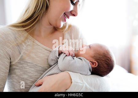 Bellissima giovane azienda madre Figlio bambino nelle braccia Foto Stock