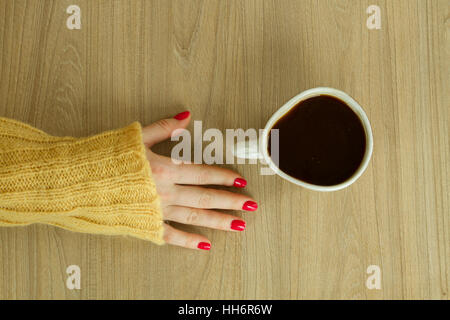 Donna con mano manicure rosso sta per prendere una tazza di caffè Foto Stock