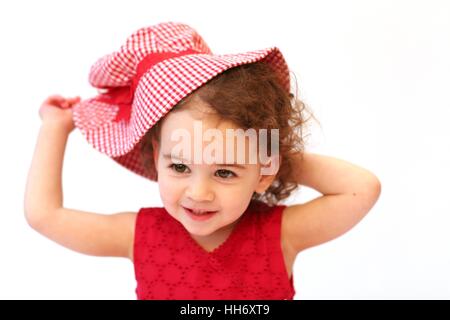 Sweet Baby girl kid bambino neonato con capelli ricci giocando con un rosso Gingham cappello per il sole, concetto di infanzia, innocente, gioia, felice Foto Stock