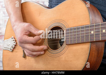 Vista ravvicinata di mano d'uomo suonare la chitarra acustica Foto Stock