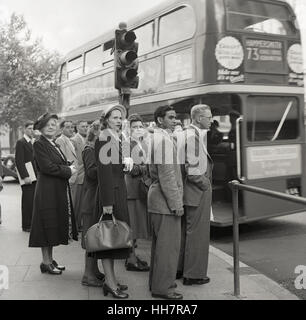 1950, storico, appena arrivato indiano d'oltremare dottorando presso l istituto di istruzione (OIE) attende con altri cittadini britannici per un autobus di Londra, Inghilterra. Foto Stock