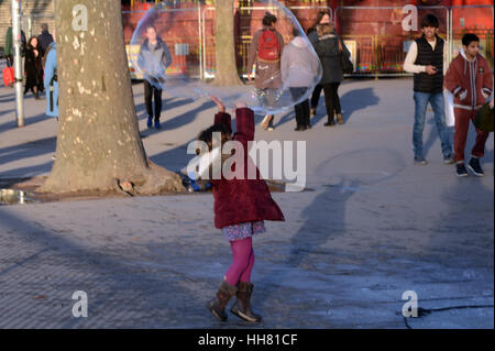 Londra, Regno Unito. Xvii gen, 2017. Bambino a caccia di bolla gigante sulla sponda sud del Tamigi. Posizione soleggiata e fredda giornata a Londra. Credito: JOHNNY ARMSTEAD/Alamy Live News Foto Stock