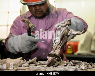 Burbank, Stati Uniti d'America. Xvii gen, 2017. Un lavoratore rimuove lo stampo fuori le statuette in bronzo durante il processo di produzione della colata le statuette in bronzo per il XXIII Incontro annuale Screen Actors Guild (SAG) Awards. Le statuette, noto come 'l'Attore', erano stati progettati originariamente da Jim Heimann e Jim Barrett, e scolpito da Edward Saenz. Poiché il primo SAG Awards nel 1995, le statuette sono state prodotte dalla American Fine Arts Fonderia di Burbank. Credito: Xinhua/Alamy Live News Foto Stock