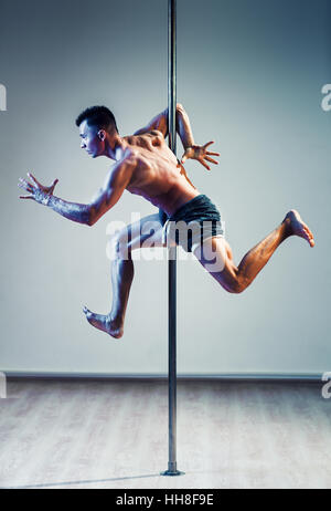 Giovane forte polo dancing uomo in esecuzione di posa. A caldo e a freddo di colori effetto. Foto Stock