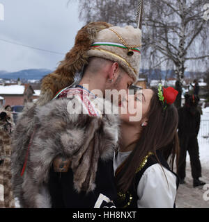 Coppia giovane in bulgaro costumi folcloristici kissing oh la strada durante la celebrazione Surva Foto Stock