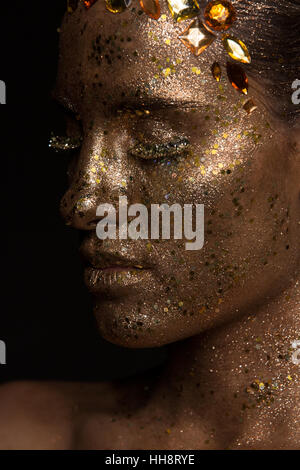 Lato verticale, giovane donna con golden glitter trucco Foto Stock