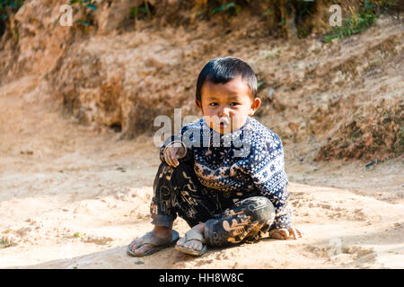 Piccolo Ragazzo seduto a terra, Palaung hilltribe, Palaung Village di Kyaukme, Stato Shan, Myanmar Foto Stock