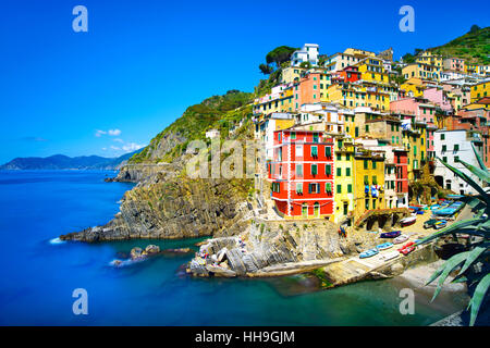 Riomaggiore villaggio sulla scogliera di rocce e mare al tramonto., Seascape in cinque terre, il Parco Nazionale delle Cinque Terre Liguria Italia Europa. Esposizione lunga Foto Stock