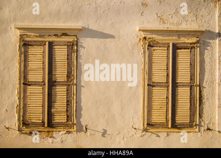 Persiane alle finestre e le pareti di una corsa verso il basso casa sull'isola di Symi. Foto Stock