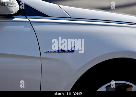 Un ibrido bianco auto Toyota con l'unità emblema blu sul lato Foto Stock