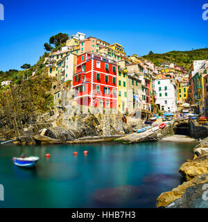 Riomaggiore villaggio sulla scogliera di rocce e mare al tramonto., Seascape in cinque terre, il Parco Nazionale delle Cinque Terre Liguria Italia Europa. Esposizione lunga Foto Stock