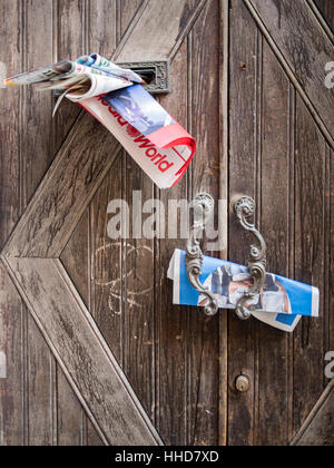 La posta indesiderata nella maniglia della porta o postero scatole in Italia. Foto Stock