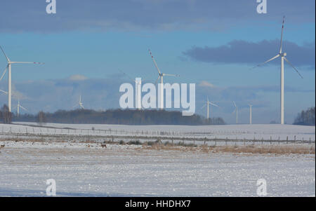 Campo invernale di turbine elettriche e cervi Foto Stock