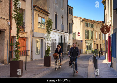 I ciclisti in un Ville Basse strada stretta, Carcassonne, Languedoc-Roussillon, Francia Foto Stock