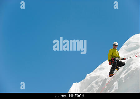 Un scalatore pratiche su una parete di ghiaccio in preparazione per la scalata Everest, Regione di Khumbu, in Nepal Foto Stock