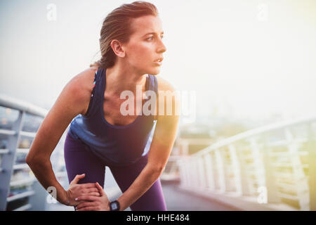 Runner gamba stiramento sulla passerella urbana Foto Stock