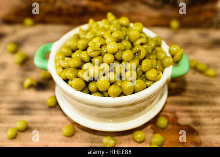 Cotto a vapore e refrigerati piselli verdi pronti a mangiare. Dolce e fresco al gusto. Qui in un beige e verde piccola ghisa smaltata pot. Foto Stock