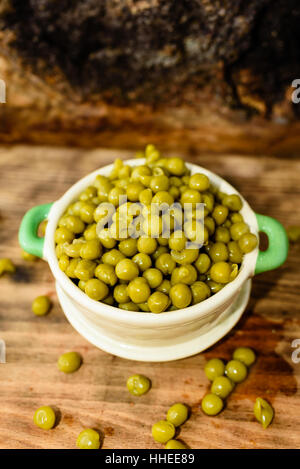 Cotto a vapore e refrigerati piselli verdi pronti a mangiare. Dolce e fresco al gusto. Qui in un beige e verde piccola ghisa smaltata pot. Foto Stock