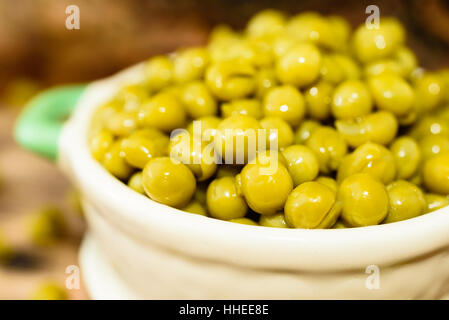 Cotto a vapore e refrigerati piselli verdi pronti a mangiare. Dolce e fresco al gusto. Qui in un beige e verde piccola ghisa smaltata pot. Foto Stock