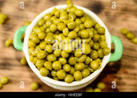 Cotto a vapore e refrigerati piselli verdi pronti a mangiare. Dolce e fresco al gusto. Qui in un beige e verde piccola ghisa smaltata pot. Foto Stock