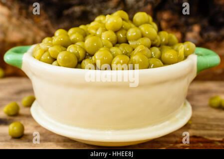 Cotto a vapore e refrigerati piselli verdi pronti a mangiare. Dolce e fresco al gusto. Qui in un beige e verde piccola ghisa smaltata pot. Foto Stock