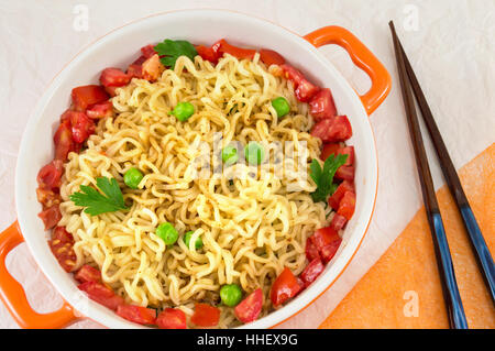 Preparate le tagliatelle con pomodoro e piselli in una ciotola Foto Stock