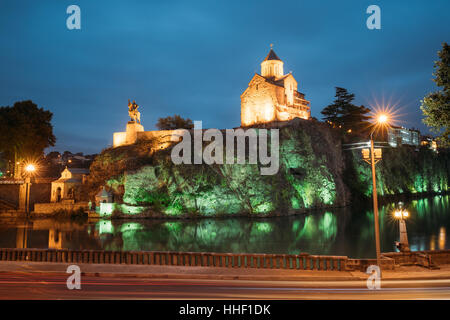 Notte illuminata di sera vista della Chiesa di Metekhi e la statua equestre del re Vakhtang Gorgasali sulla scogliera di Metekhi nel vecchio e storico Distric Foto Stock