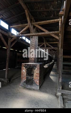 Interno di una capanna in legno uno dei pochi sopravvissuti donna dormitori con letti a castello e a legna camino ad Auschwitz 11-Birkenau vicino a OS Foto Stock