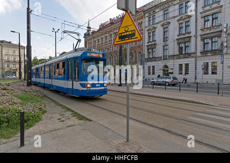 Una fermata del tram che si avvicinano ad un tram principale terminale in ul Pawia ( Pawia Street) e una strada pedonale incrocio con un tram in segno di avvertimento a Cracovia, Polonia Foto Stock