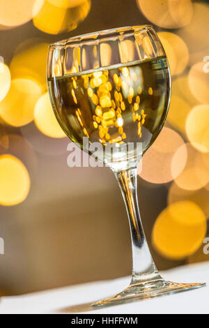 Un bicchiere di Pinot Grigio vino bianco con luci scintillanti in background Foto Stock