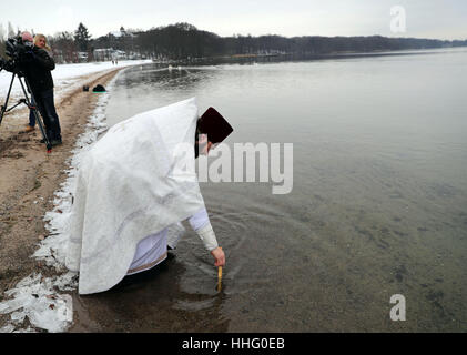 Schwerin, Germania. Xix gen, 2017. Dionisij Idavain, sacerdote della chiesa Russian-Orthodox del Patriarcato di Mosca in Germania, sommerge la croce goldne nell'acqua durante il quinto acqua Russian-Orthodox santificazione in Schwerin, Germania, 19 gennaio 2017. Secondo il calendario Gregoriano, 19 Gennaio è il giorno del battesimo di Gesù. Foto: Jens Büttner/dpa-Zentralbild/dpa/Alamy Live News Foto Stock