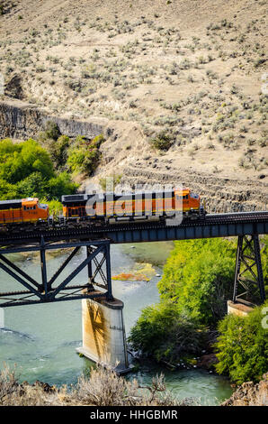 Un BNSF treno attraversa un ponte sopra il fiume Deschutes in Oregon orientale Foto Stock