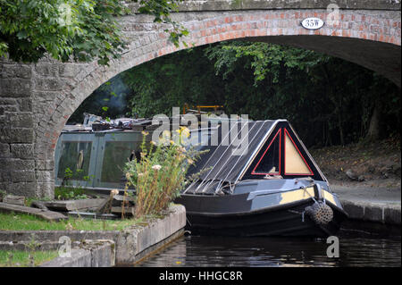 Barca stretta passando un ponte come si naviga in Llangollen Canal in Galles. Foto Stock