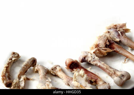 Le ossa del pollo con scarti di carne su sfondo bianco Foto Stock