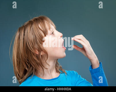 Ragazzo che finge di essere mangiare qualcosa di invisibile. Foto Stock