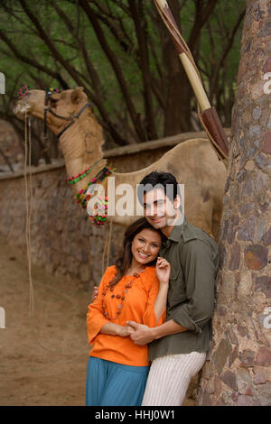 Coppia giovane abbracciando, camel in background Foto Stock