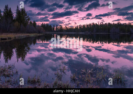 Ancora un laghetto in Breckenridge, Colorado riflette perfettamente una rosa e viola sunrise Foto Stock