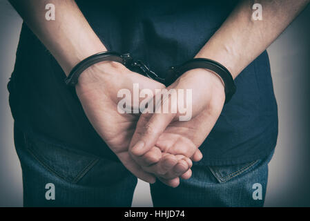 Arrestato uomo in manette con le mani dietro la schiena close up Foto Stock