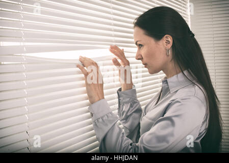 Ritratto di giovane donna d'affari guardando fuori della finestra Foto Stock