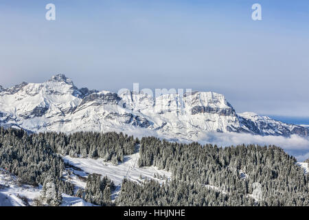 Incantevole paesaggio invernale sul massiccio del Monte Bianco con la vista della Chaine des Aravis sopra le nuvole e villaggi. Foto Stock