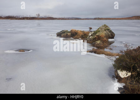 Un piccolo Lochan su Rannock Moor nel gennaio ricoperto di ghiaccio Foto Stock