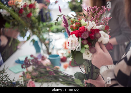 Workshop fioraio, rendendo mazzi di fiori e decorazioni. Soft focus Foto Stock