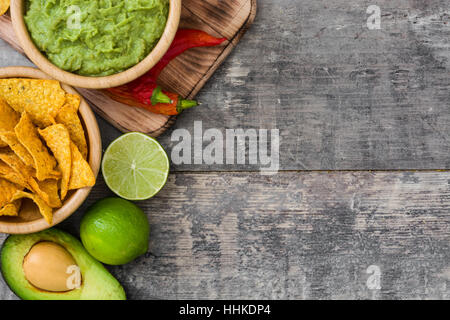 Nachos, guacamole e ingredienti su sfondo di legno Foto Stock