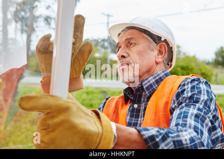 Senior come competenti montatore finestra Installazione nuova finestra Foto Stock