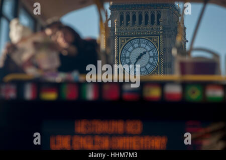 Una scorciata prospettiva di un tour bus con turisti leggendo la loro mappa di Londra e in background, il clockface di Elisabetta La Torre del parlamento britannico, il 17 gennaio 2017, a Londra Inghilterra. Foto Stock